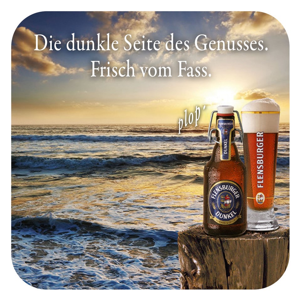 Flensburger Dunkel Bierflasche und Glas stehen auf einem Holzstamm am Strand. Der Sonnenuntergang reflektiert sich auf dem Wasser. Im Hintergrund steht der Text: "Die dunkle Seite des Genusses. Frisch vom Fass."