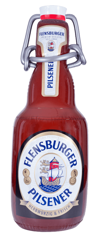 Flensburger Pilsener in einer braunen, aufblasbaren Flasche mit einem weißen und roten Etikett. Das Etikett zeigt ein Schiff und den Schriftzug "Flensburger Pilsener".