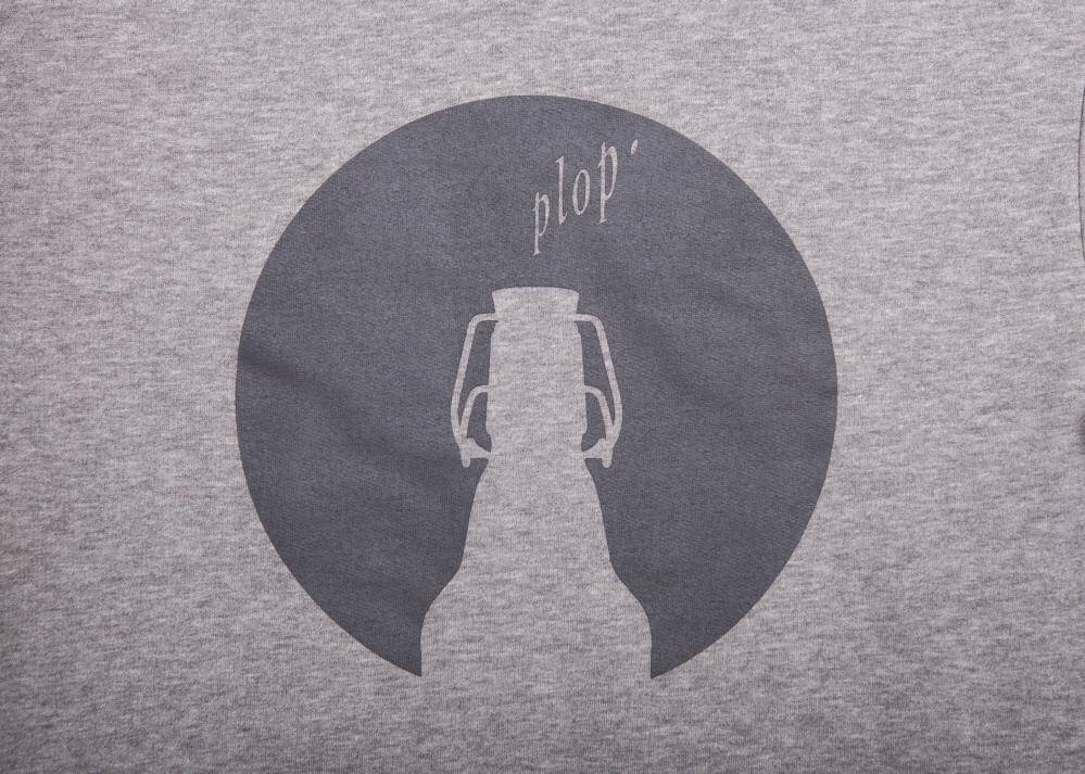 Grauer Pullover mit einem runden Aufdruck, der eine Flasche und das Wort „plop’“ zeigt. Der Stil ist lässig und geeignet für Freizeitmode.